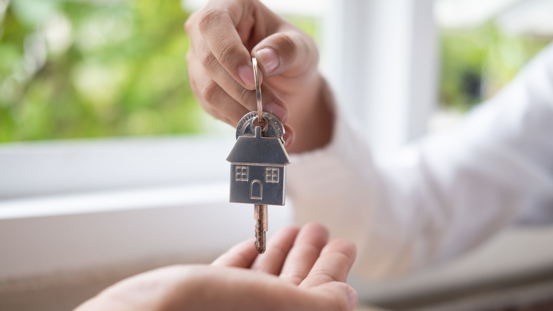 Hand holding house keychain
