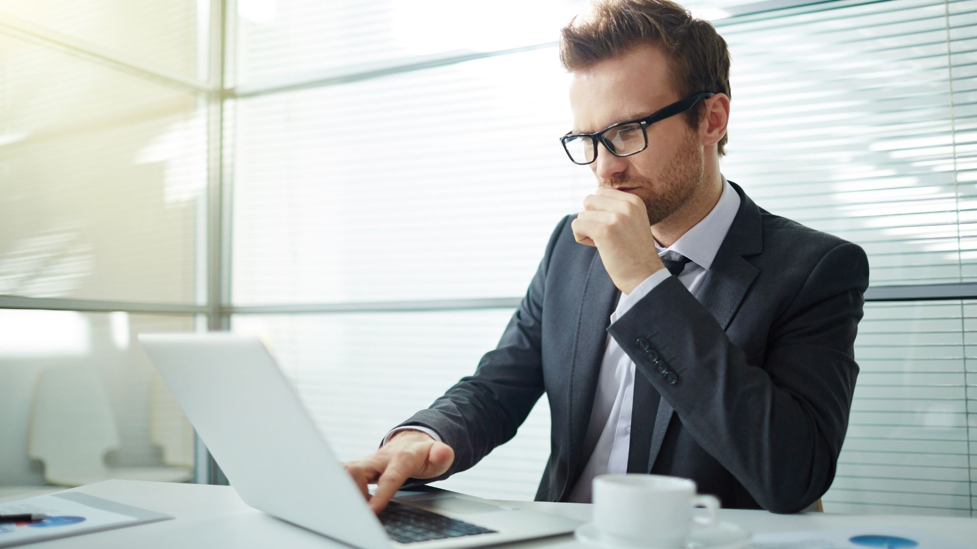 Businessman analyzing data on laptop at office desk