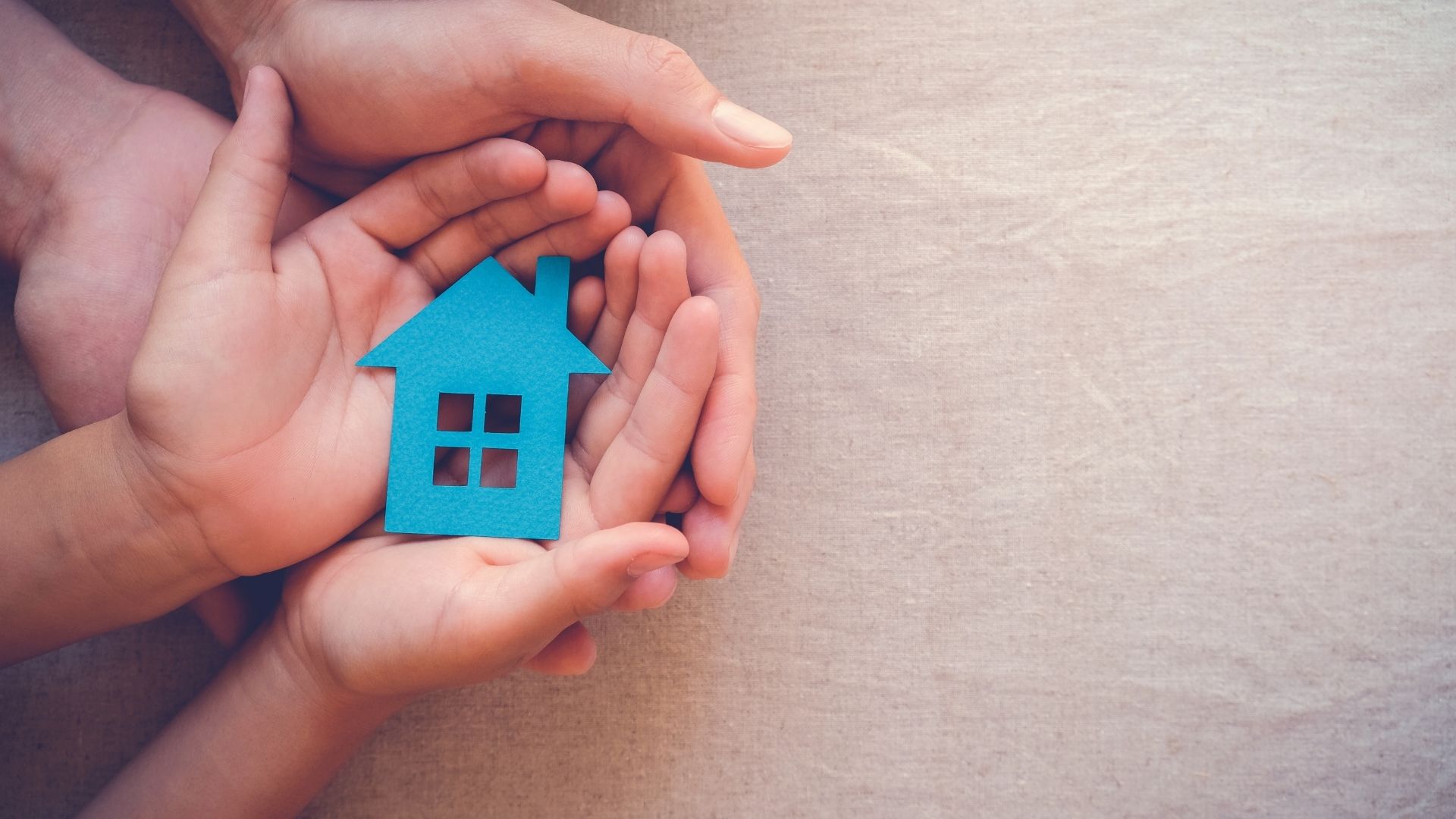 Hands holding blue paper house, family home concept