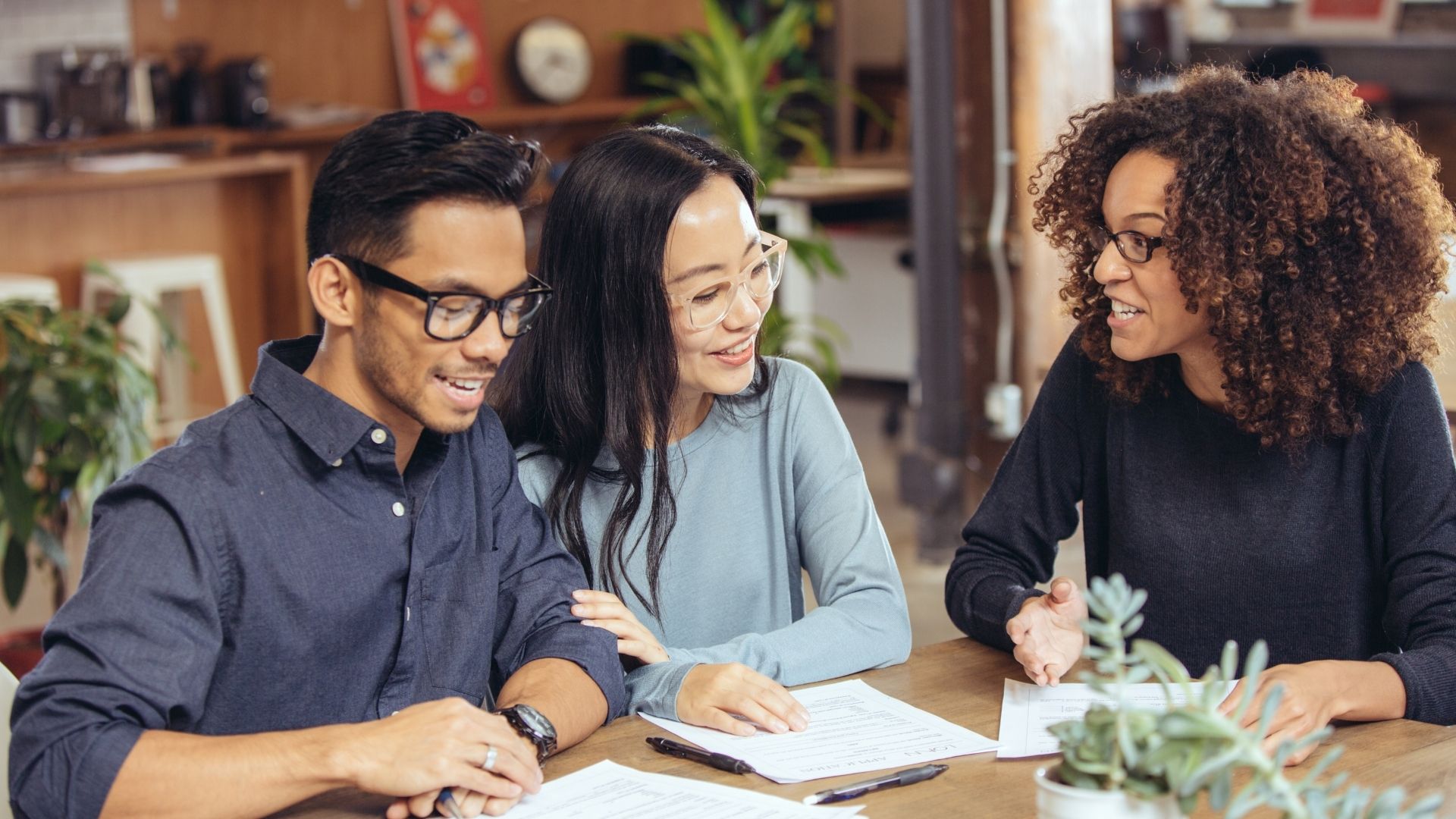 Diverse team collaboratively working at a wooden table