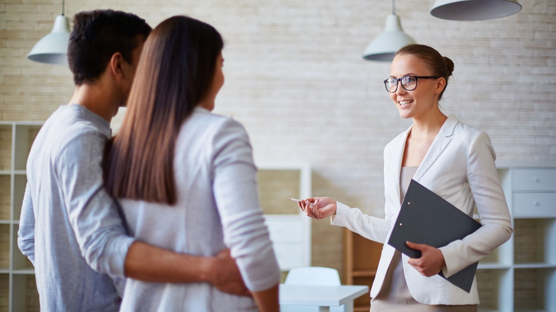 Real estate agent discussing with couple in modern office