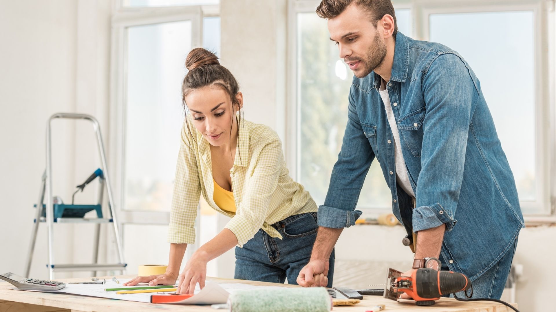 Man and woman planning renovation with tools on table