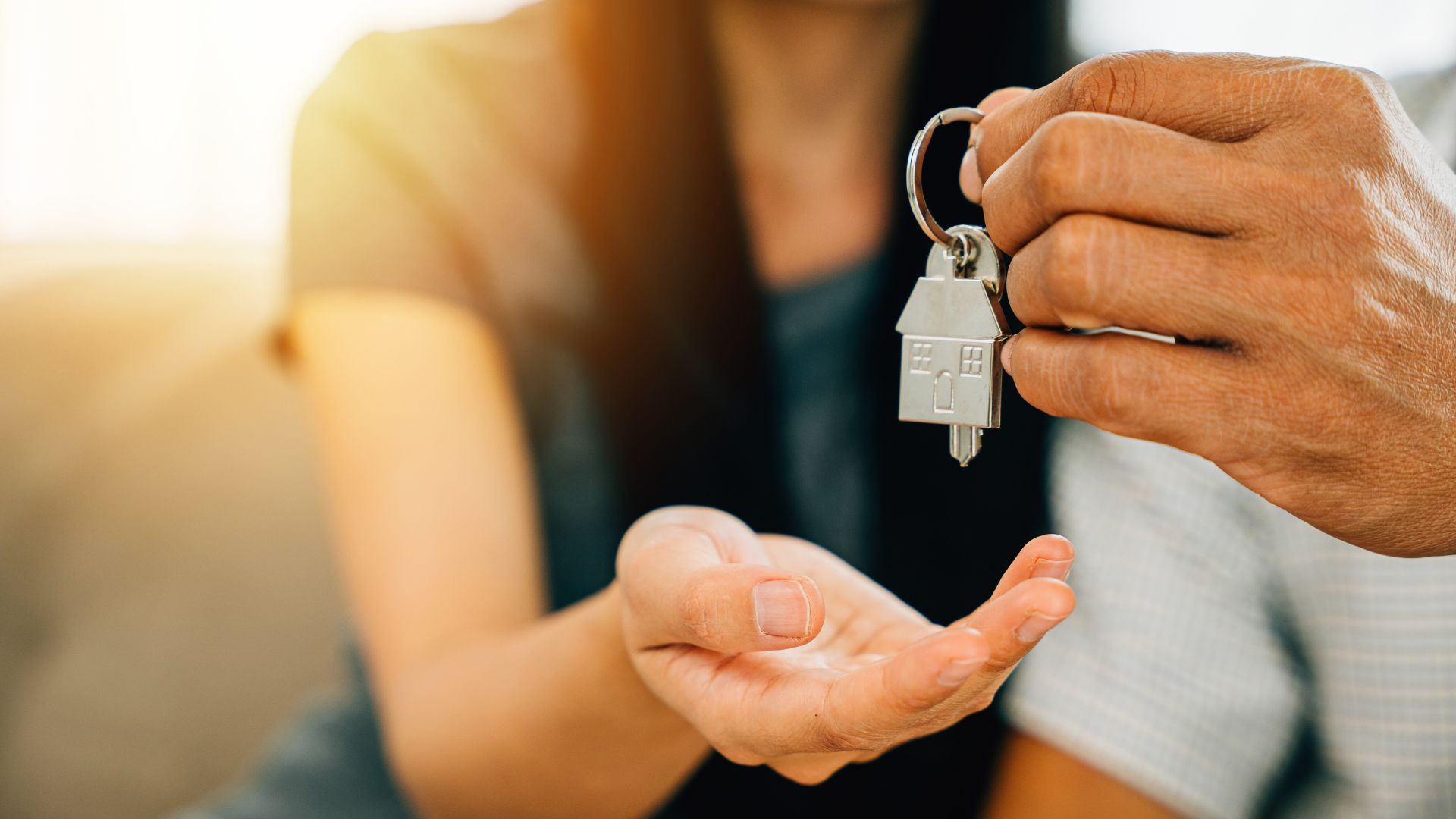 Person receiving house keys from anothers hand