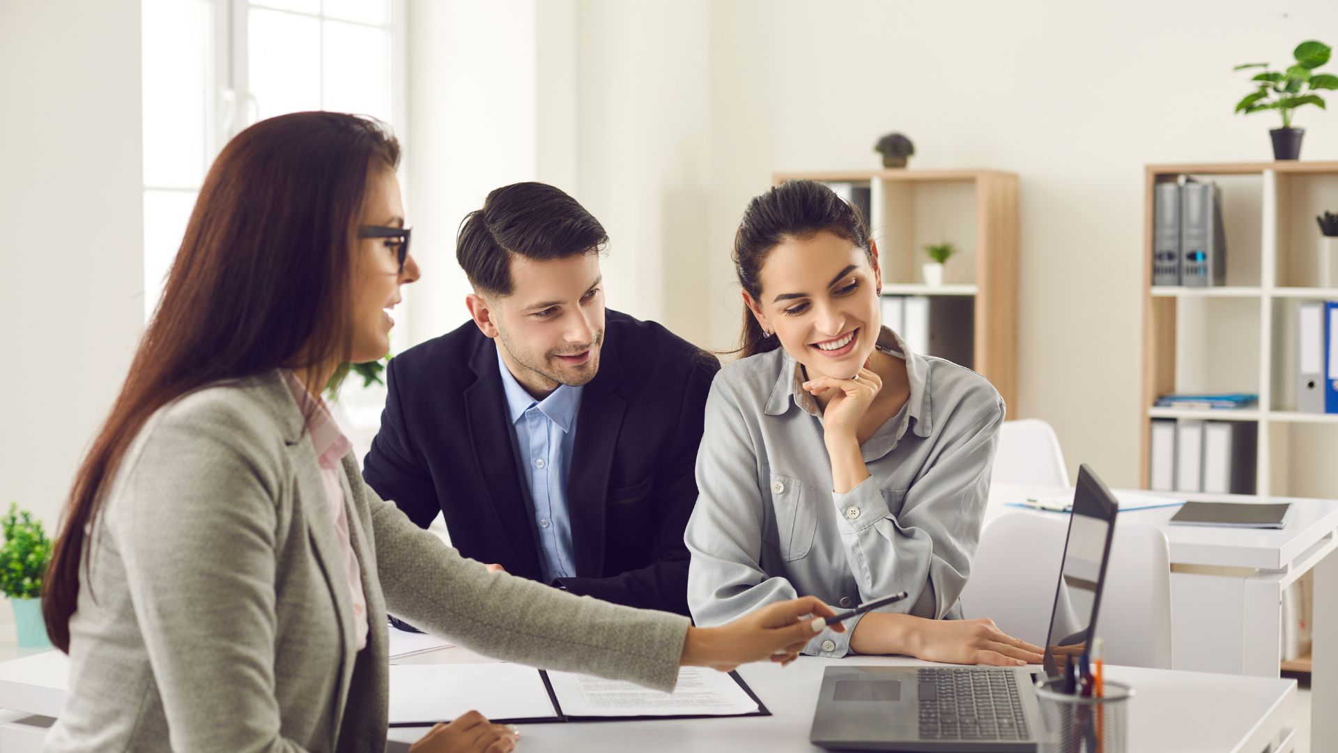 Three professionals discussing at a modern office desk