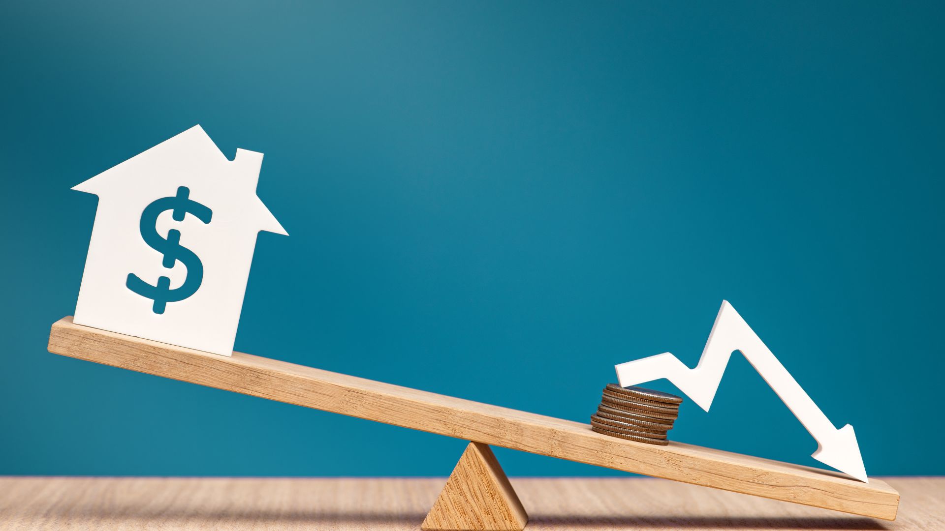 House symbol with dollar sign balancing on seesaw