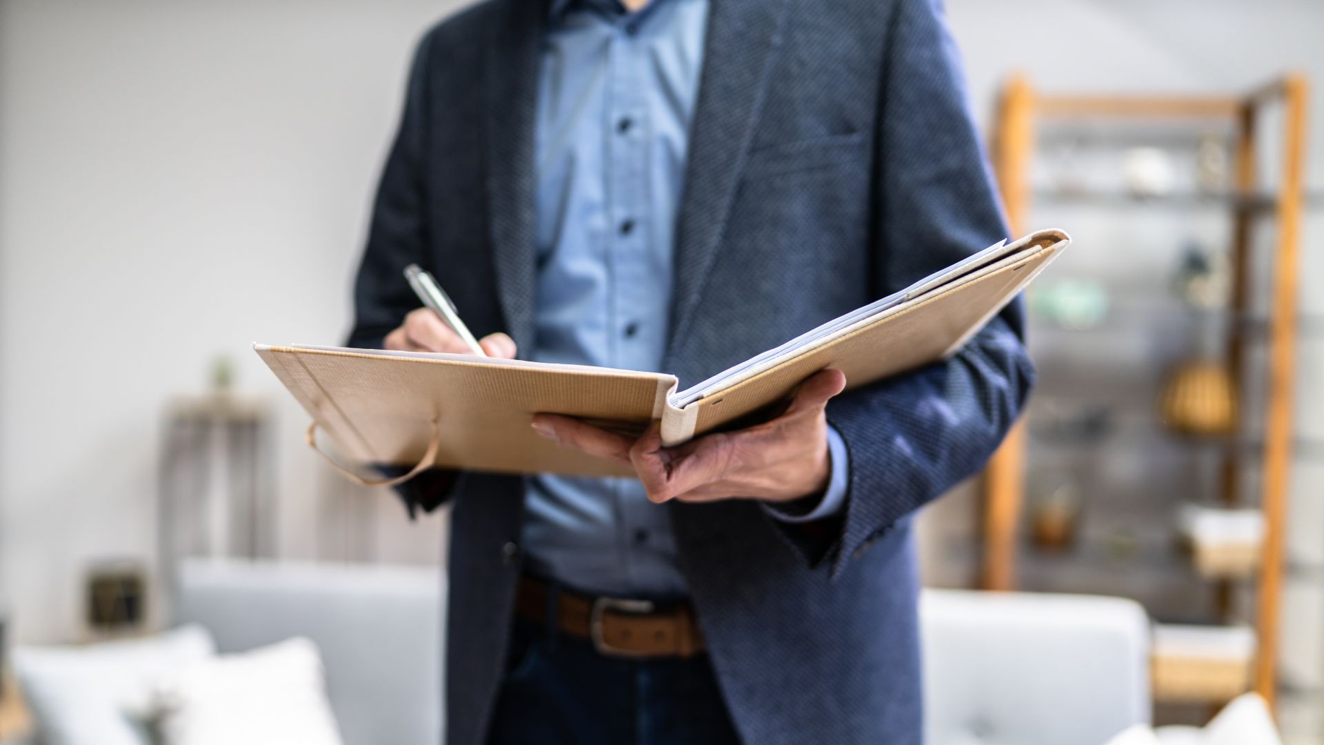 Man writing in notebook in modern office