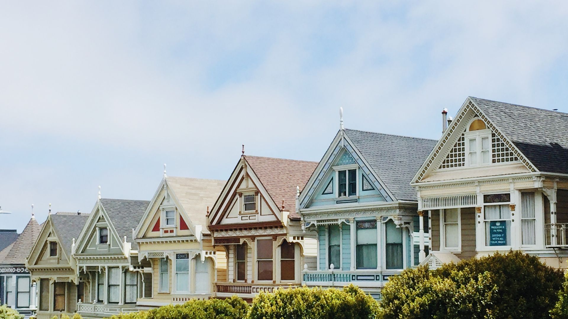 Colorful Victorian houses in a row under blue sky