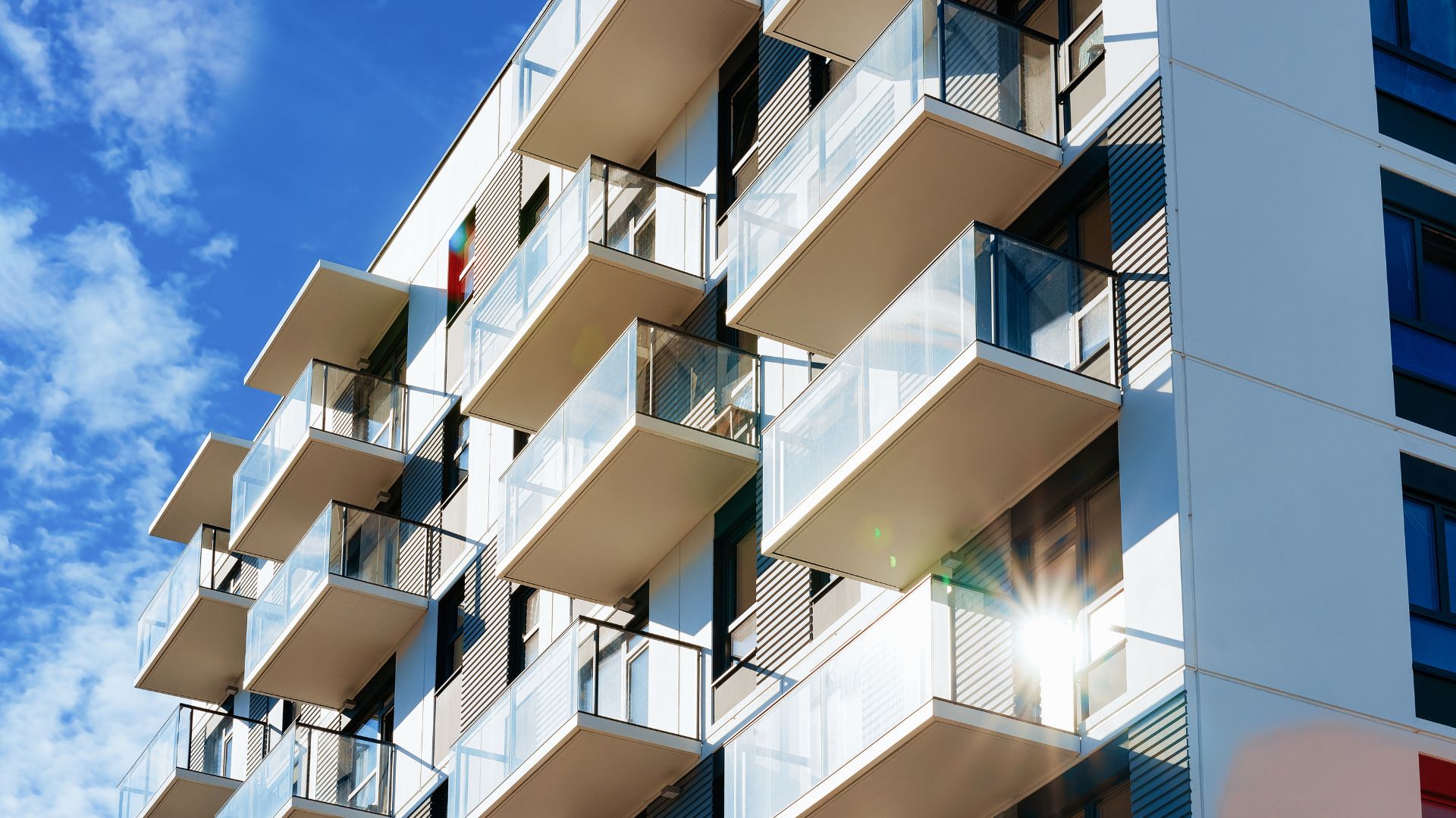 Modern apartment building with balconies under blue sky